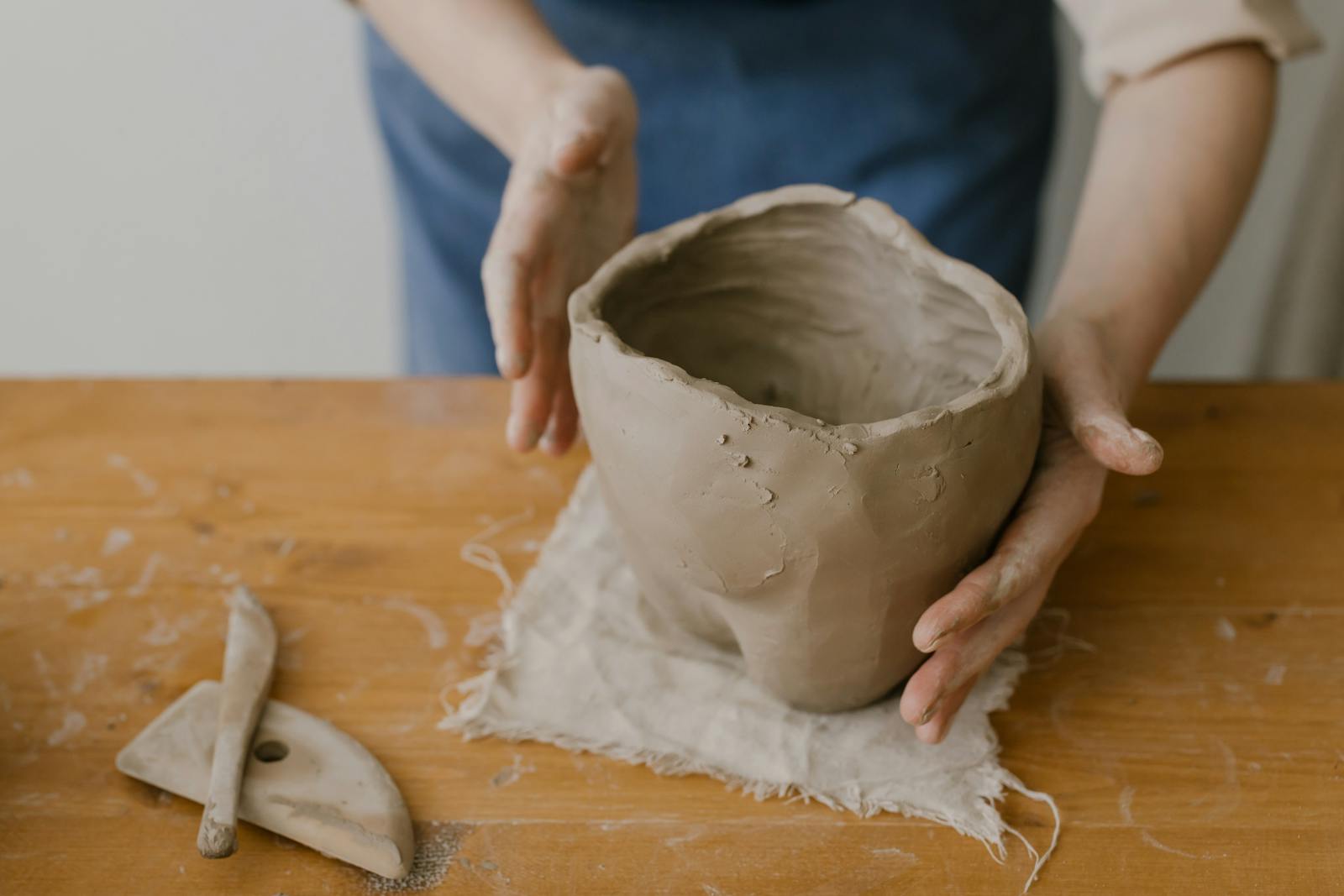 Discover the art of pottery with this hands-on clay sculpting image perfect for craft enthusiasts.